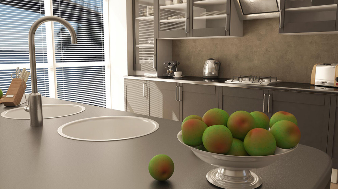 Une cuisine avec un bol de fruits colorés sur le comptoir.