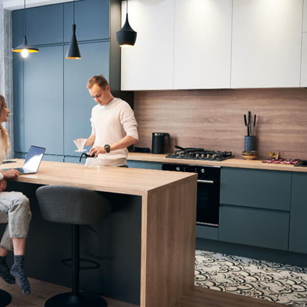 Un homme et une femme sont assis à un comptoir de cuisine, discutant ensemble dans un cadre convivial.
